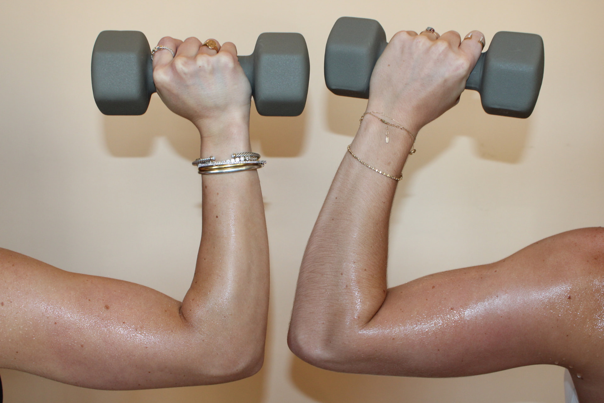 Two sets of arms lifting light dumbbells, full bleed